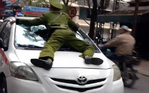 Hình ảnh chiến sĩ công an phường bị tài xế lái taxi hãng Group hất lên nắp ca pô