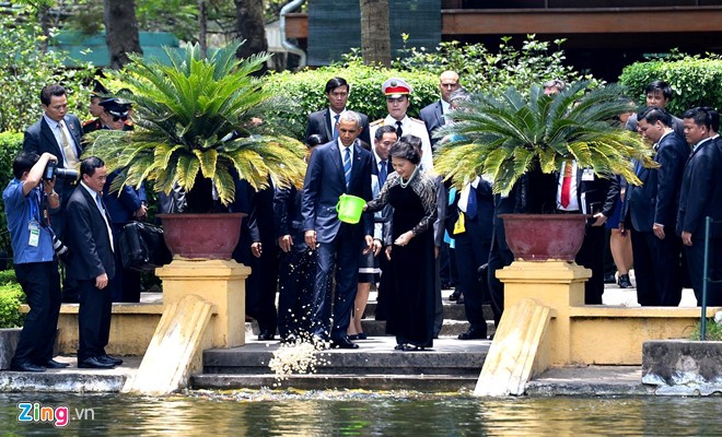 Chủ tịch Quốc hội Nguyễn Thị Kim Ngân hướng dẫn Tổng thống Mỹ cách cho cá ăn tại Ao cá Bác Hồ - Ảnh: Zing