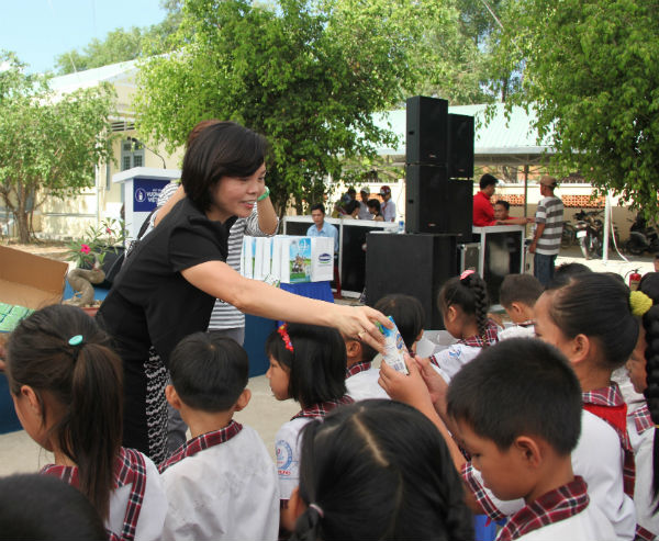 Bà Bùi Thị Hương - Giám đốc Đối ngoại Vinamilk trao sữa cho trẻ em