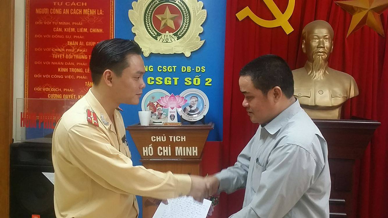 Thượng úy Nguyễn Tuấn Cường - Đội phó Đội CSGT số 2 tiếp nhận thư cảm ơn của gia đình chủ phương tiện bị mất cắp