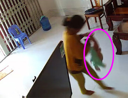 Hình ảnh cháu bé bị dốc ngược được cắt từ clip trẻ bị bạo hành tại nhà riêng ở Bình Thuận