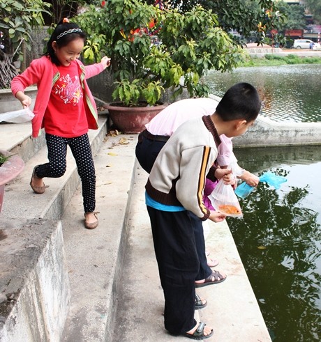 Theo đúng truyền thống hàng năm, anh Ngô Văn Thịnh (40 tuổi, Đội Cấn) lại dẫn con đi thả cá. Lũ trẻ rất háo hức khi được tự tay thả cá vàng xuống hồ.