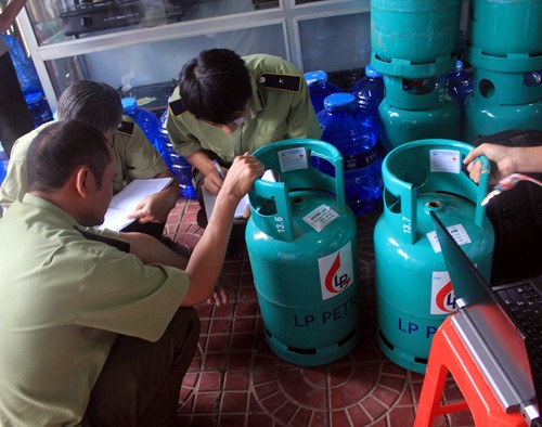 Quản lý thị trường kiểm tra các bình gas của Công ty Long Phụng - Ảnh: Phạm Anh 