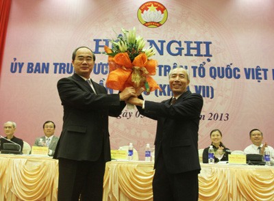 Tân Chủ tịch UB TƯ MTTQ Nguyễn Thiện Nhân nhận hoa chúc mừng của người tiền nhiệm Huỳnh Đảm.