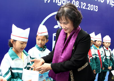 Phó Chủ tịch Quốc hội Nguyễn Thị Kim Ngân trao sữa Vinamilk cho các em học sinh. Ảnh: N. N