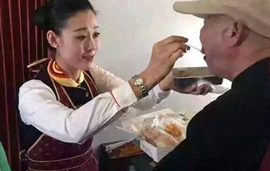 Cảm động nữ tiếp viên hàng không quỳ gối chăm sóc người già 